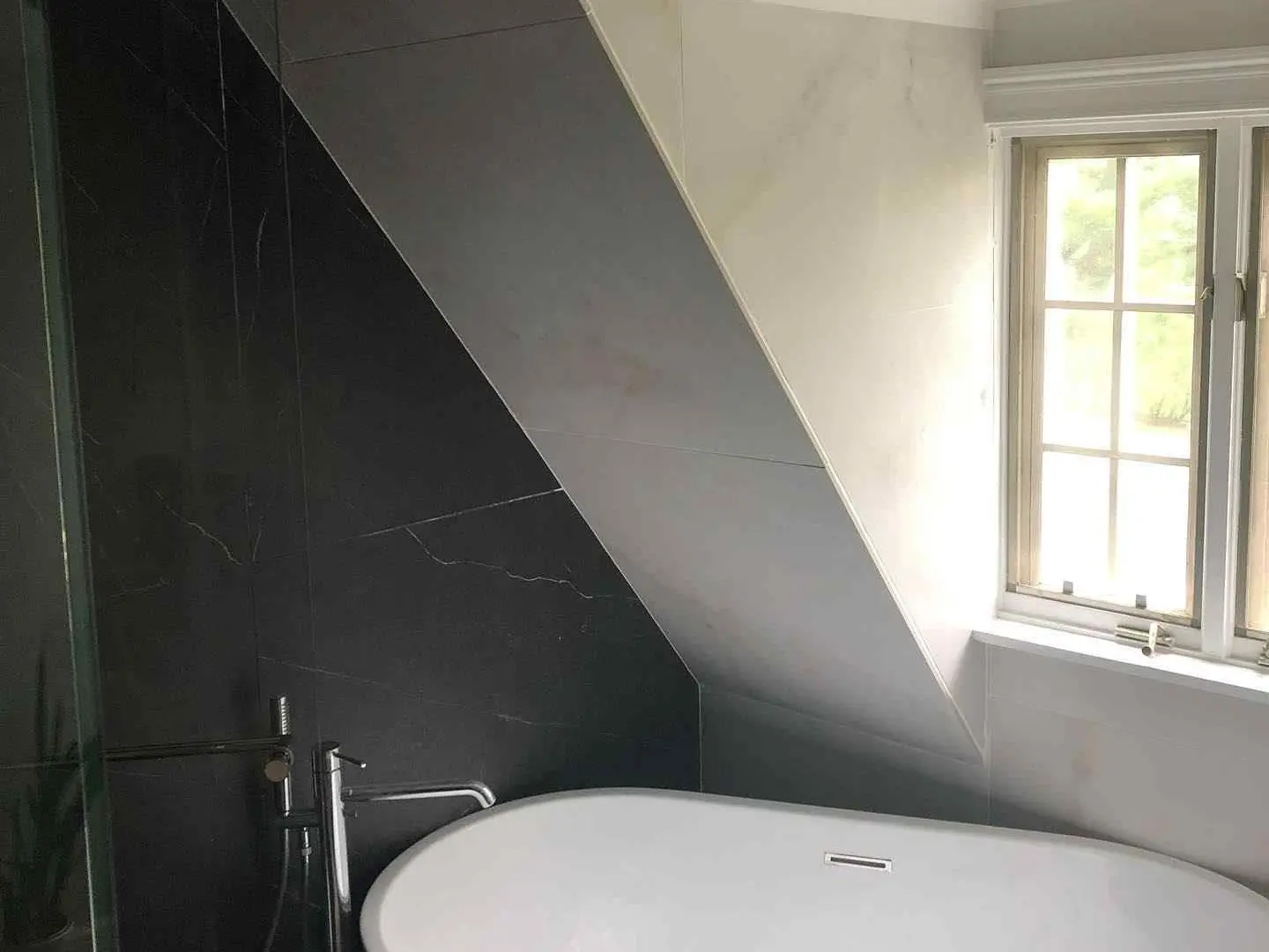 Bathroom with a freestanding tub and honed marble