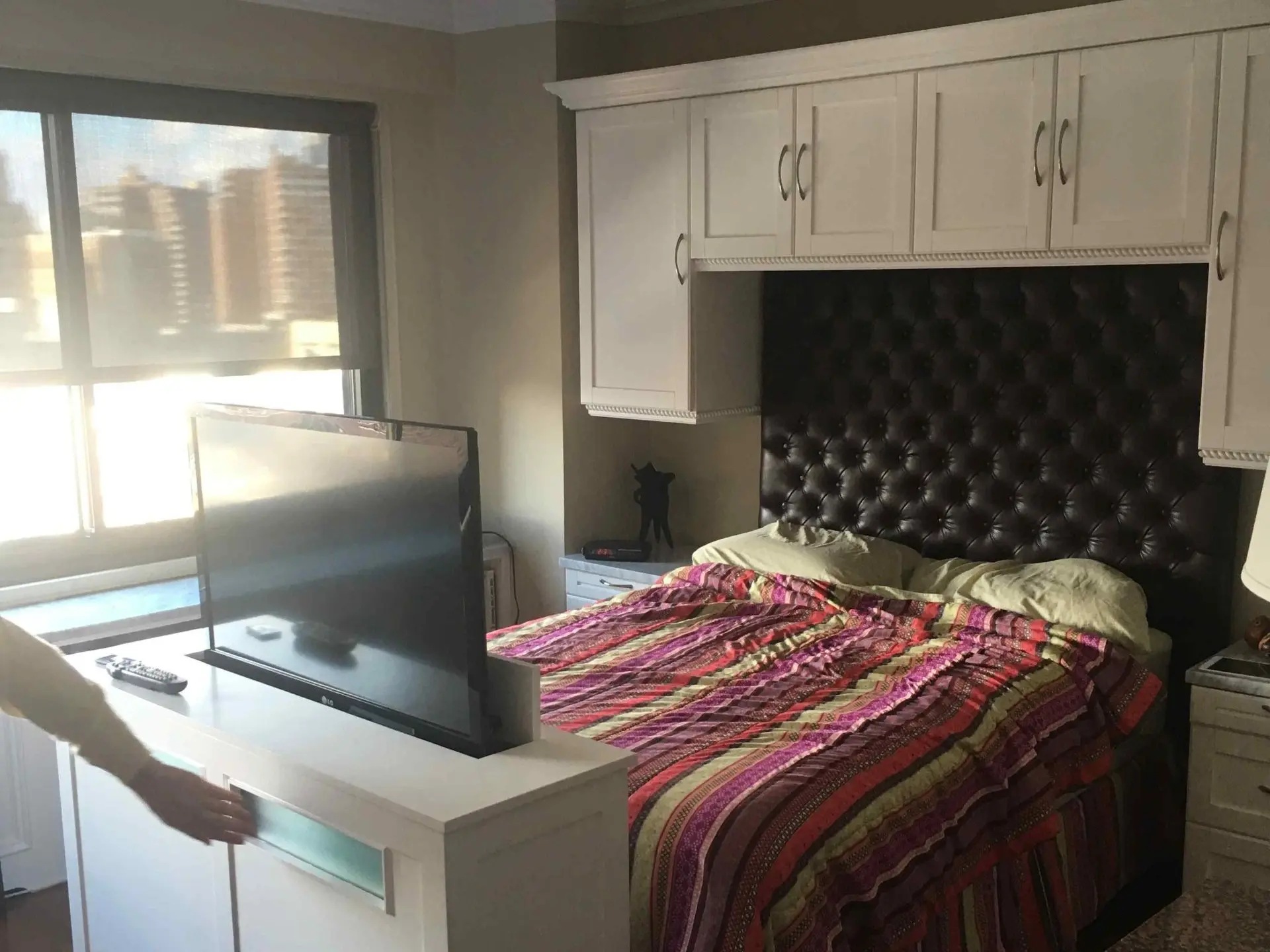 Bedroom wall of cabinets with a television lift